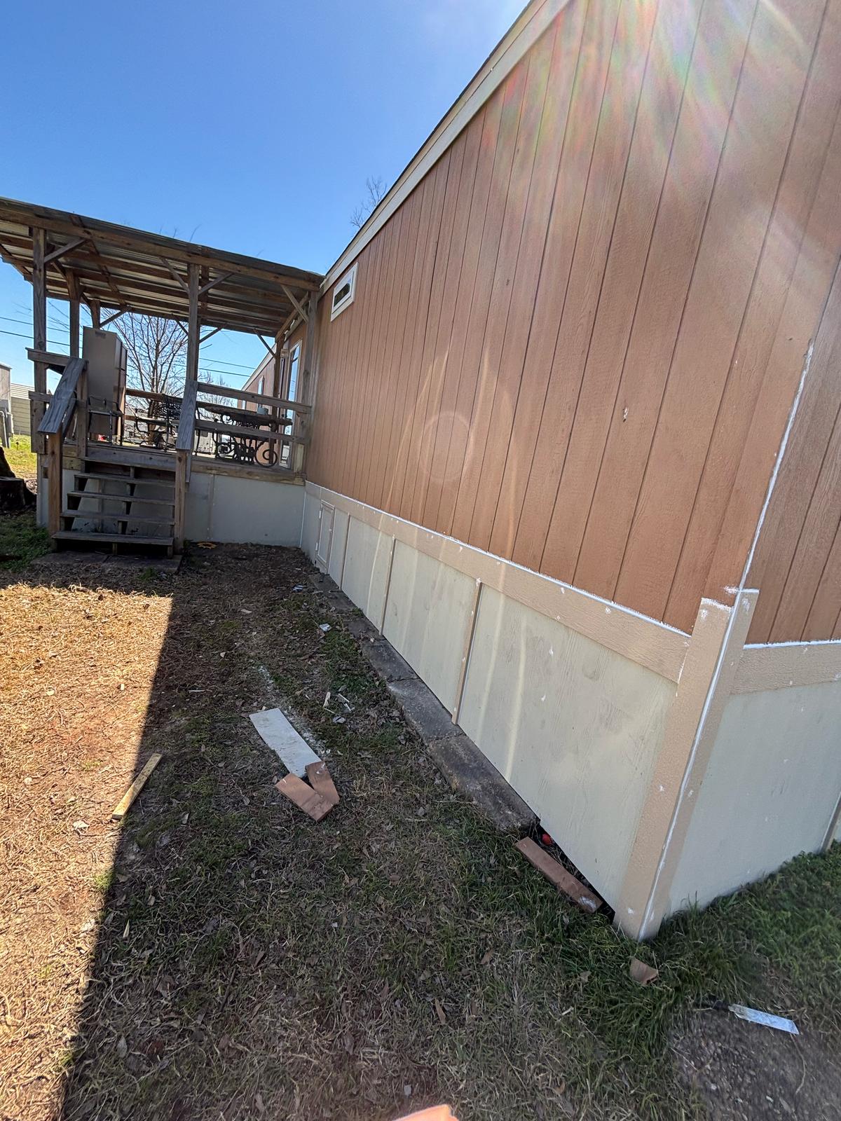 Exterior view of a building with a brown wall and white base paneling.