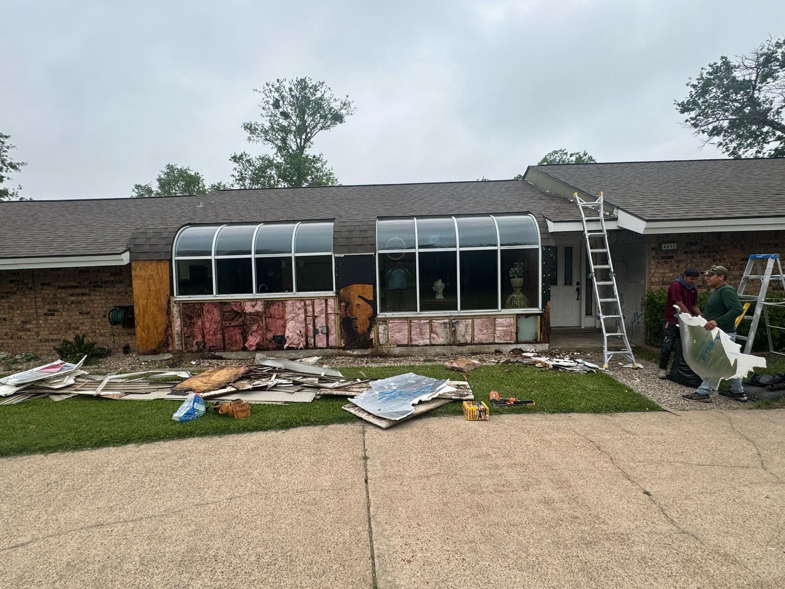 A greenhouse attached to a rustic house under renovation.