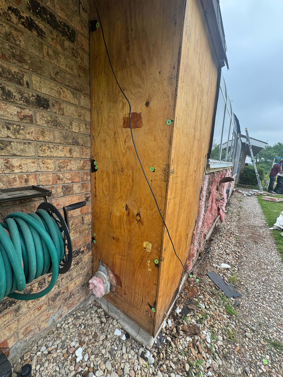 Rusty metal door with a chain and padlock on a brick building.
