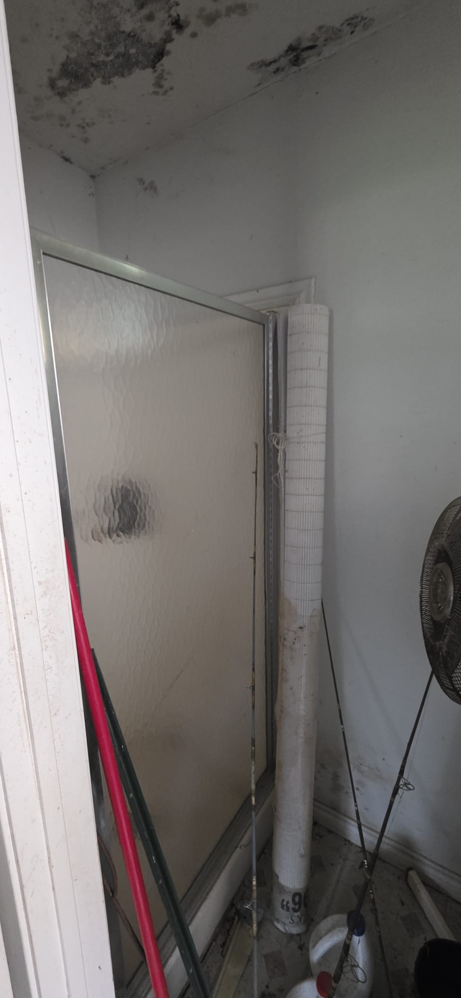 A closed white door with a rolled-up mat leaning beside it.