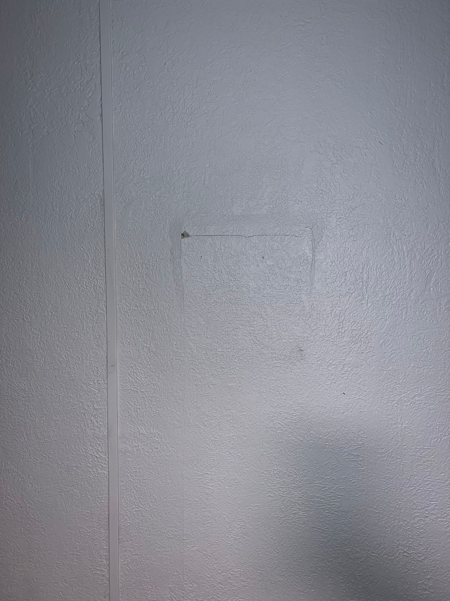 Subtle square outline on a plain wall.