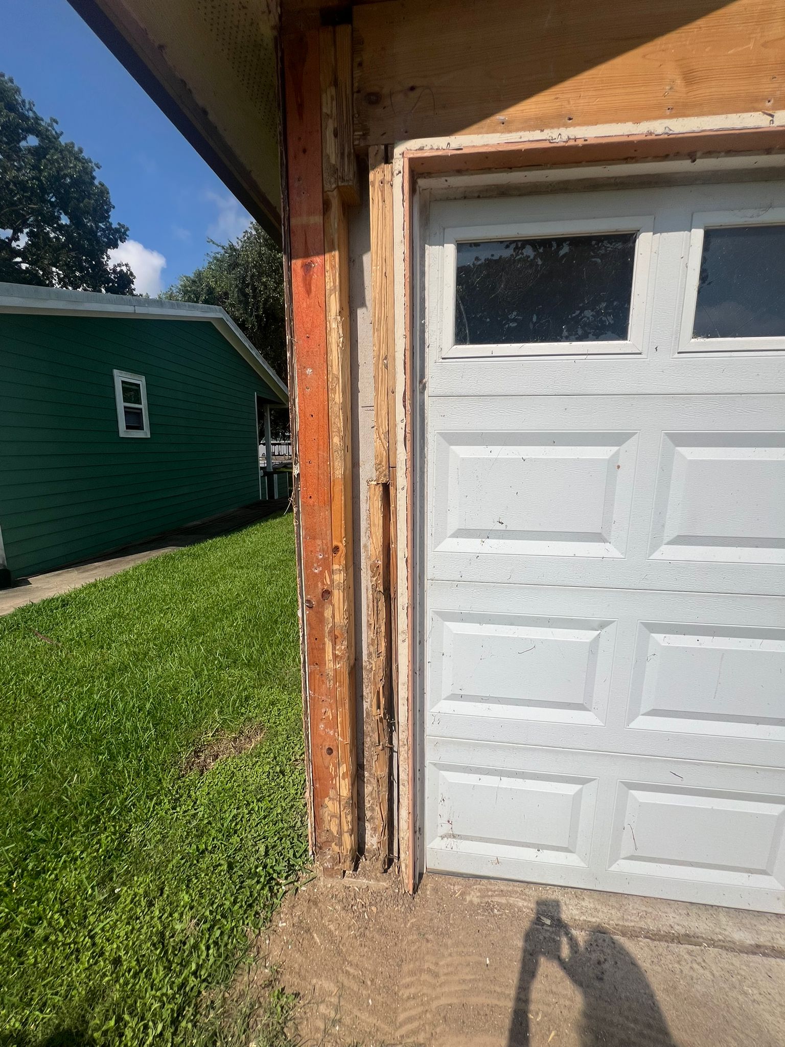 Partially removed garage door frame showing wood and insulation.