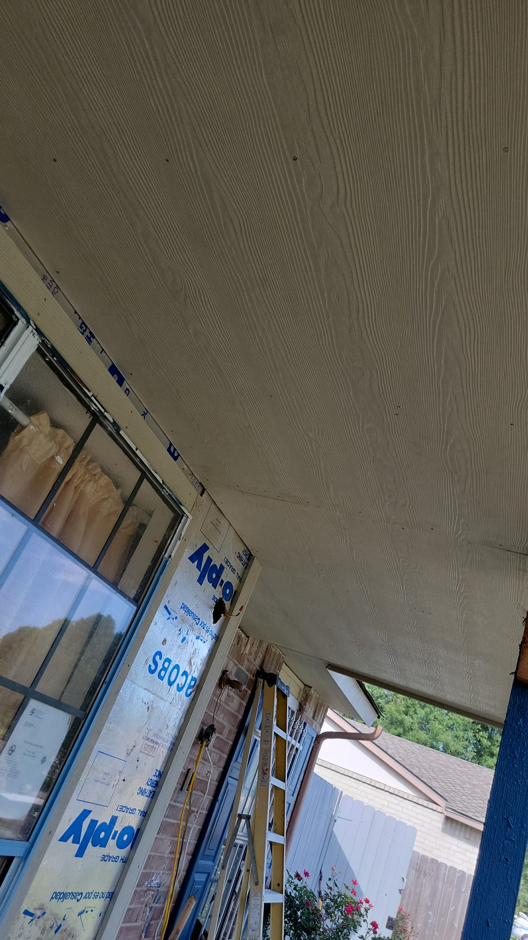 View of a ceiling with air conditioning units and windows below.