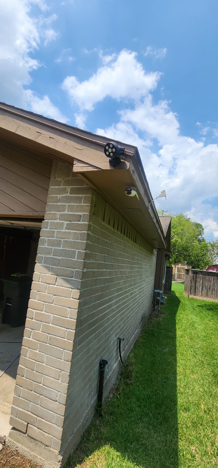 Security cameras installed on a house's exterior roof edge.