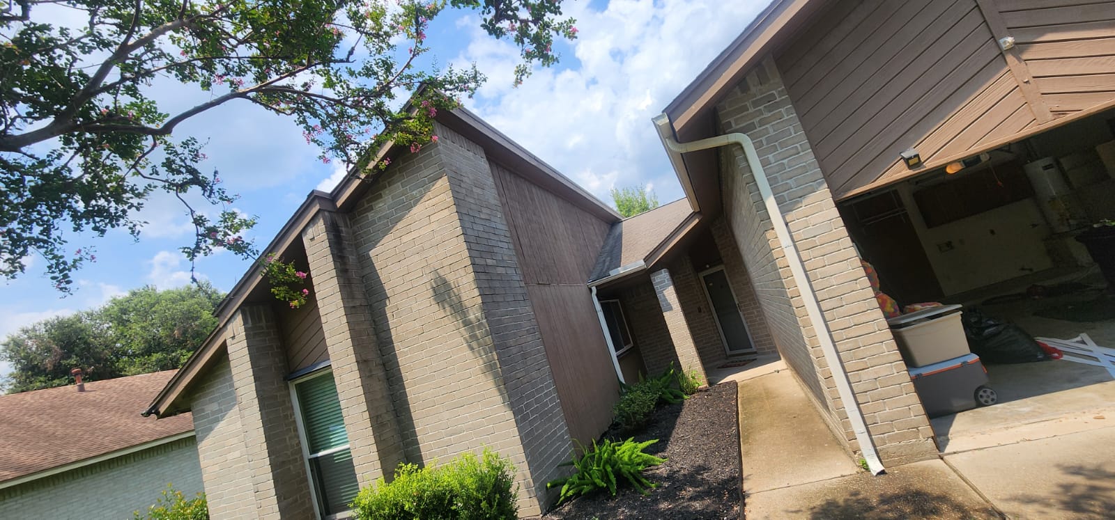 Modern residential building with brick exterior and clear sky.