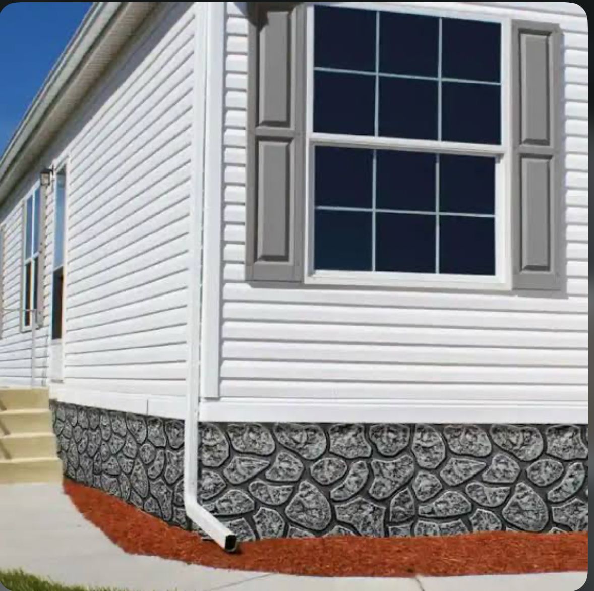 White house exterior with stone foundation and steps.