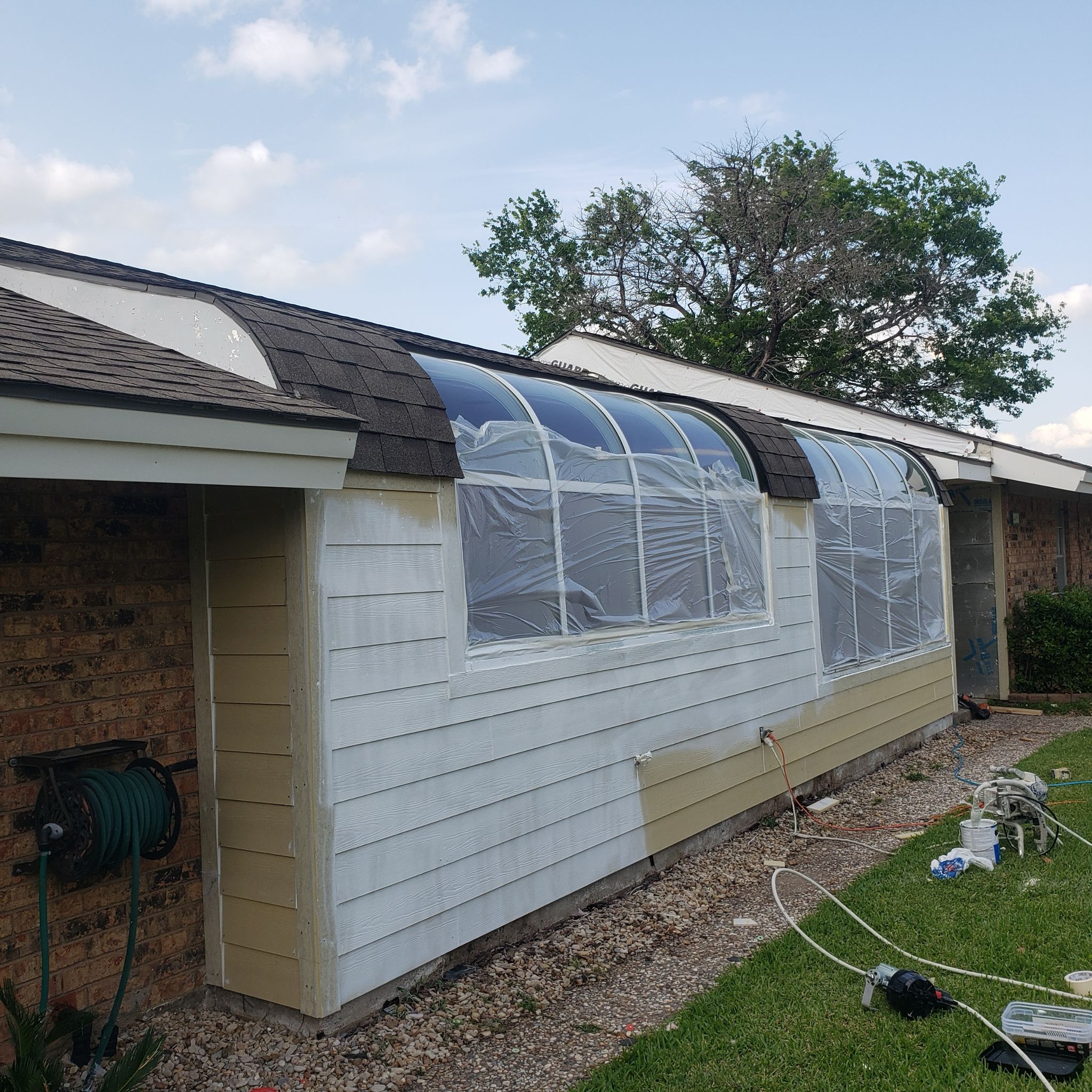 A house with a temporary plastic covering over windows during renovation.