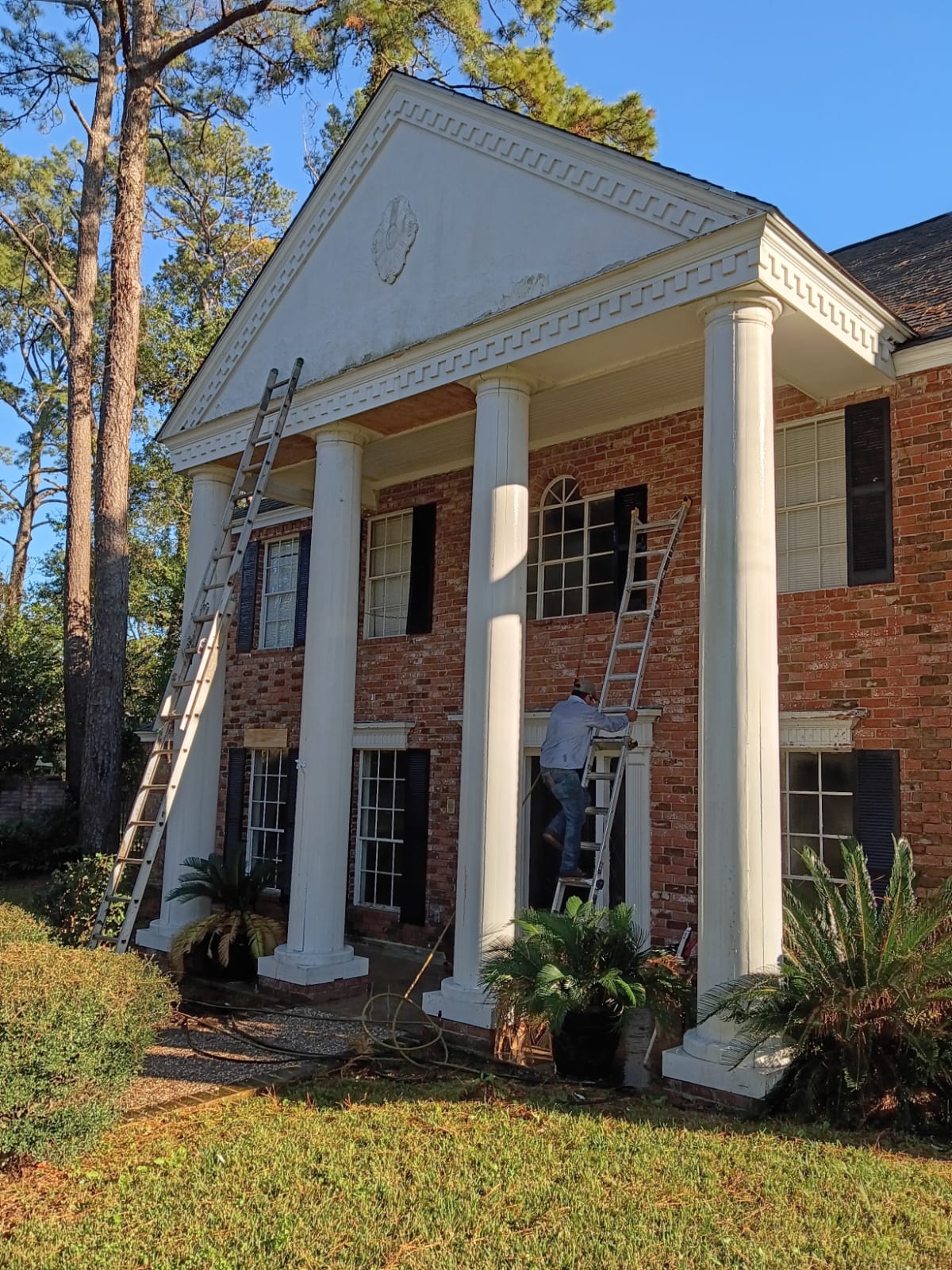 Large brick house with tall white columns at the entrance.